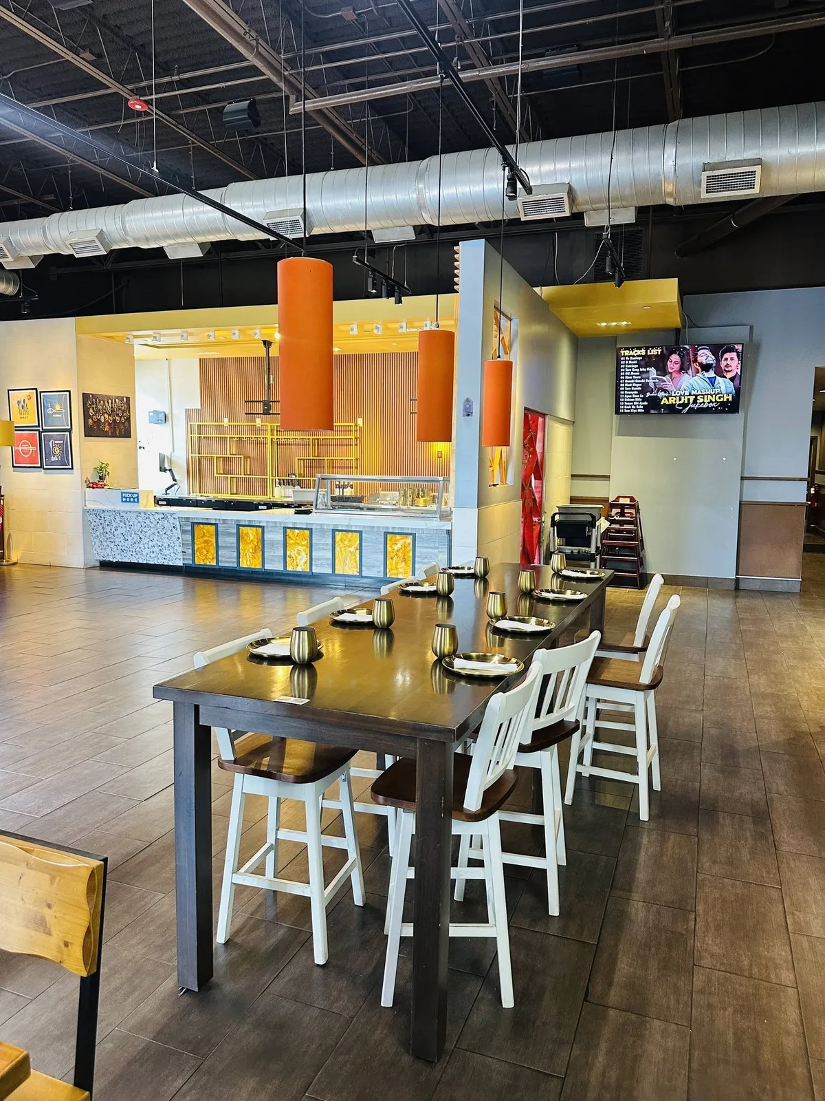 The buffet counter at Indian Curry with onyx panels, orange pendants and a PICK UP HERE sign.