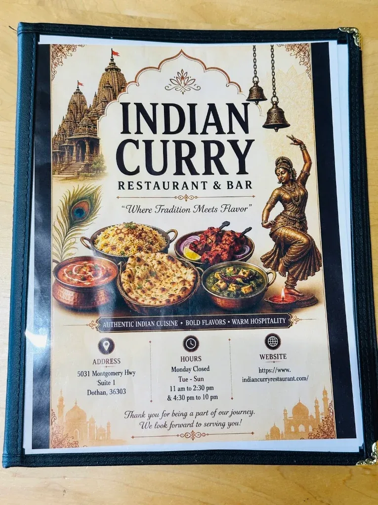 The printed menu of Indian Curry Restaurant & Bar in its black leather folder, the cusped arch framing the name above the hours and the address.